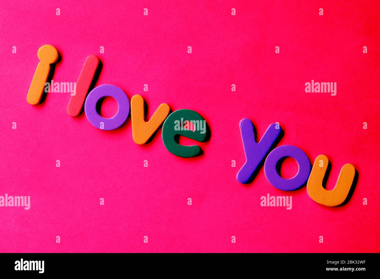Ti amo carta su sfondo rosa. Ti amo concetto. Lettera colorata che ortografa le parole che ti amo. Foto Stock