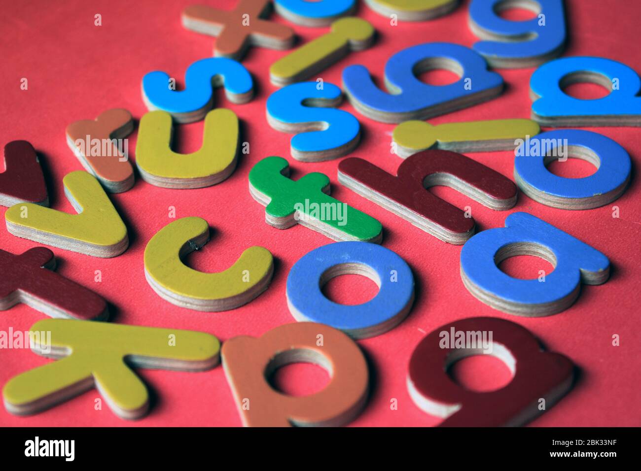 Alfabeti inglesi. Colorate lettere inglesi di legno su sfondo rosa. Foto Stock