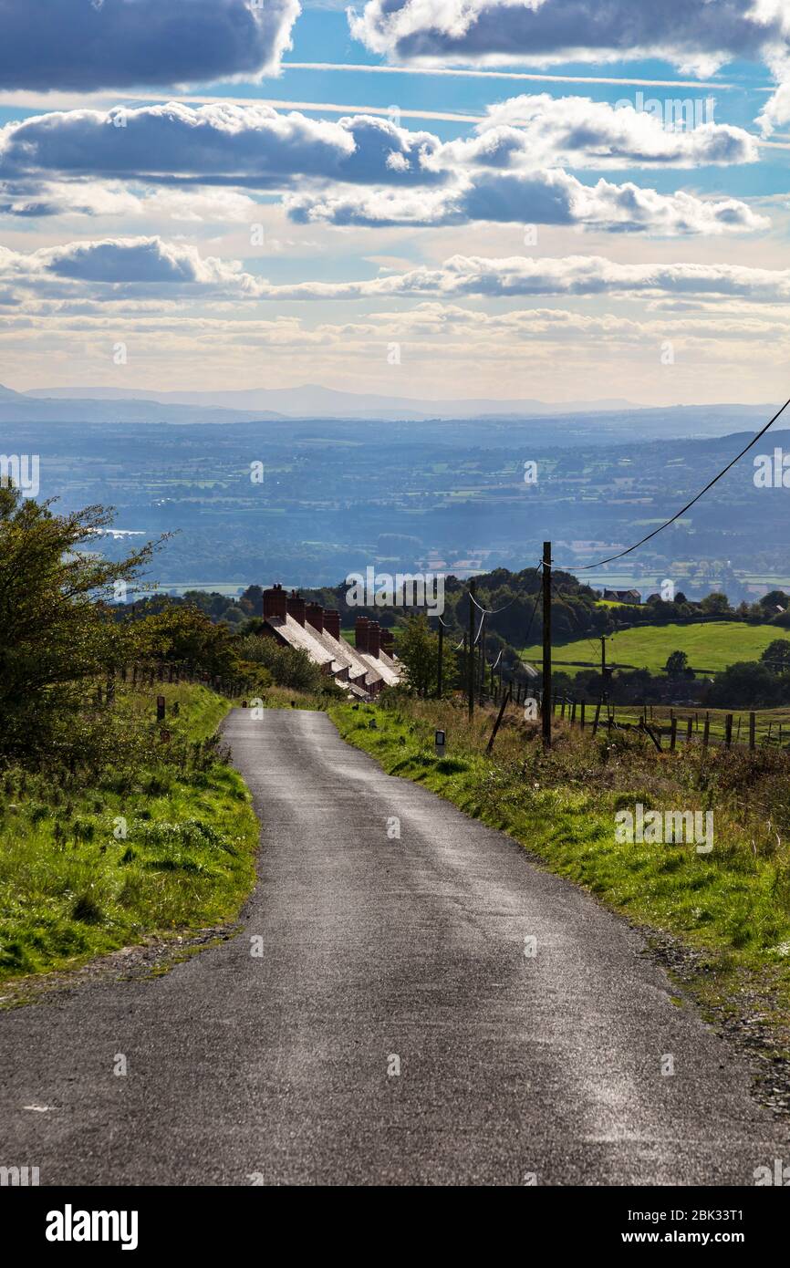 Un avvolgimento lane scende Titterstone Clee Hill verso Ludlow, passato una fila di lavoratori di cava cottages, Shropshire, Regno Unito Foto Stock