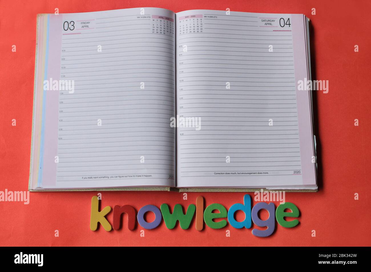 La parola conoscenza scritta su sfondo rosso con la pagina Diario. Foto Stock