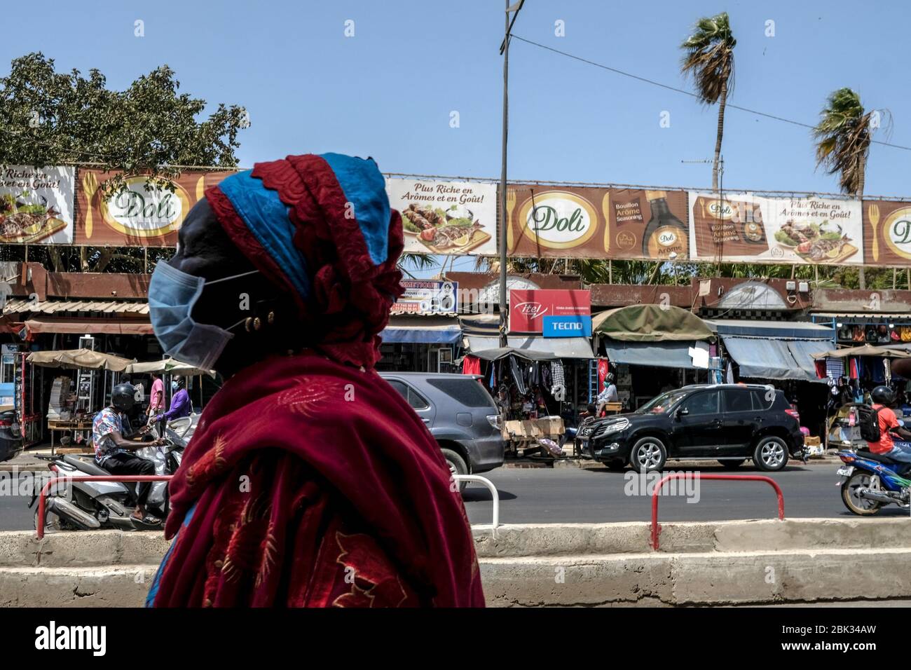 Dakar, Senegal. 30 Aprile 2020. Una donna che indossa una maschera facciale passa davanti a un mercato a Dakar, Senegal, 30 aprile 2020. Il Ministero senegalese della Sanità e dell'azione sociale ha riferito venerdì 91 nuovi casi di COVID-19, portando il numero totale a 1,024 casi nel paese. Credit: Eddy Peters/Xinhua/Alamy Live News Foto Stock