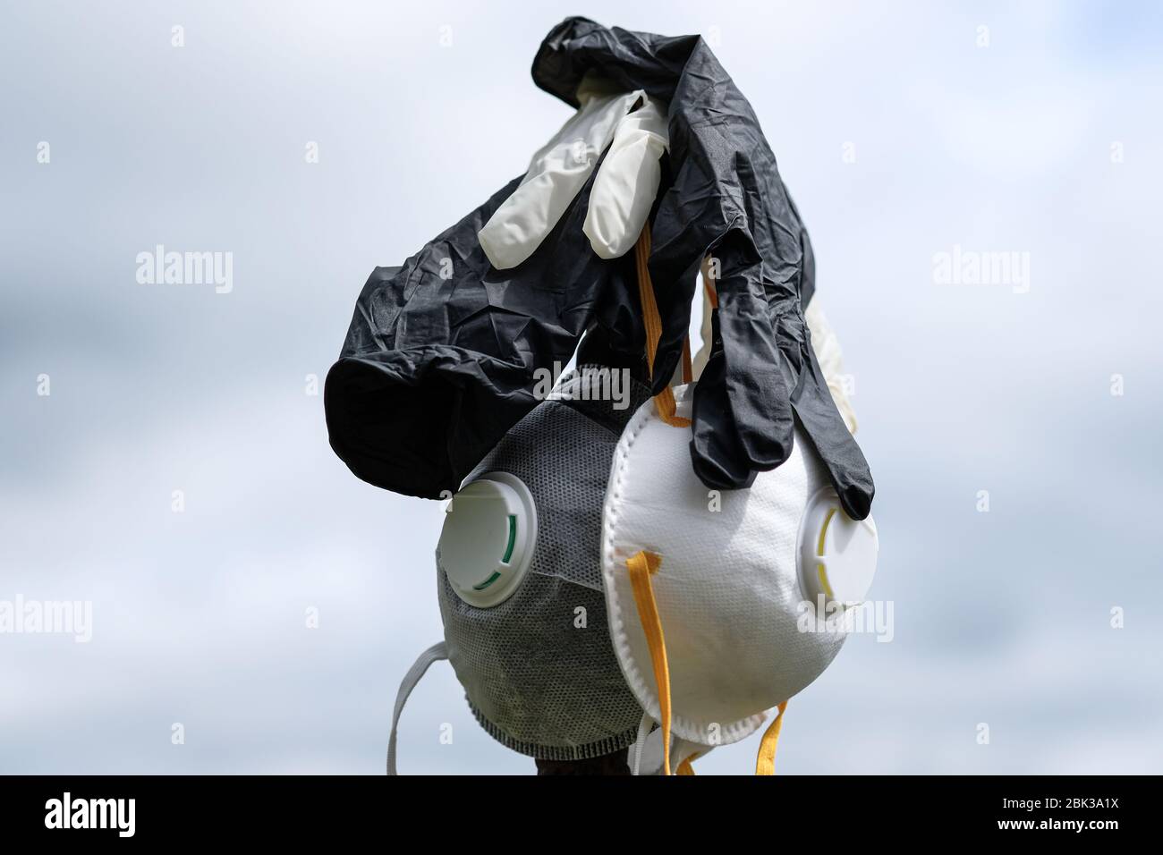 Maschera protettiva FFP2 isolata e guanti di plastica spazzatura su sfondo lucido malattia da coronavirus inquinamento da rifiuti Foto Stock