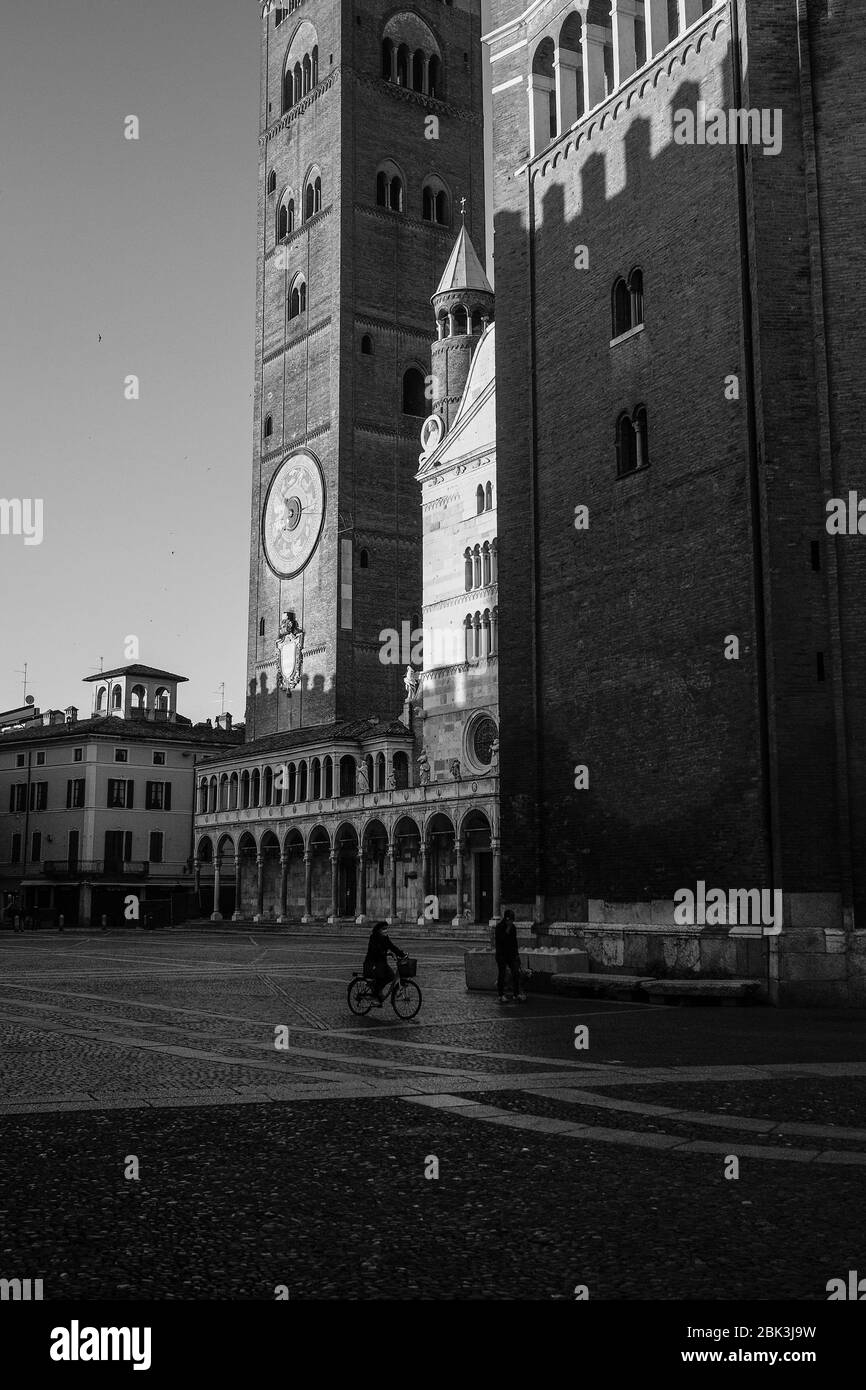 Cremona, Lombardia, Italia - 30 aprile - 1 maggio 2020 - persone in bicicletta a piedi cane a piedi nel centro durante il covid 19 blocco e crisi economica Foto Stock