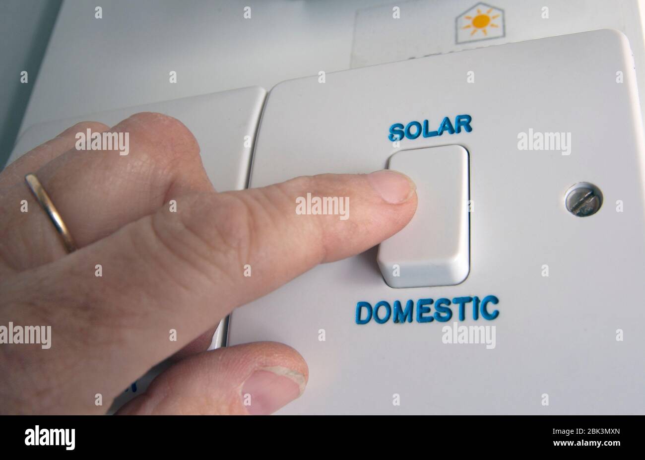 persona che accende l'interruttore di alimentazione solare domestico Foto Stock
