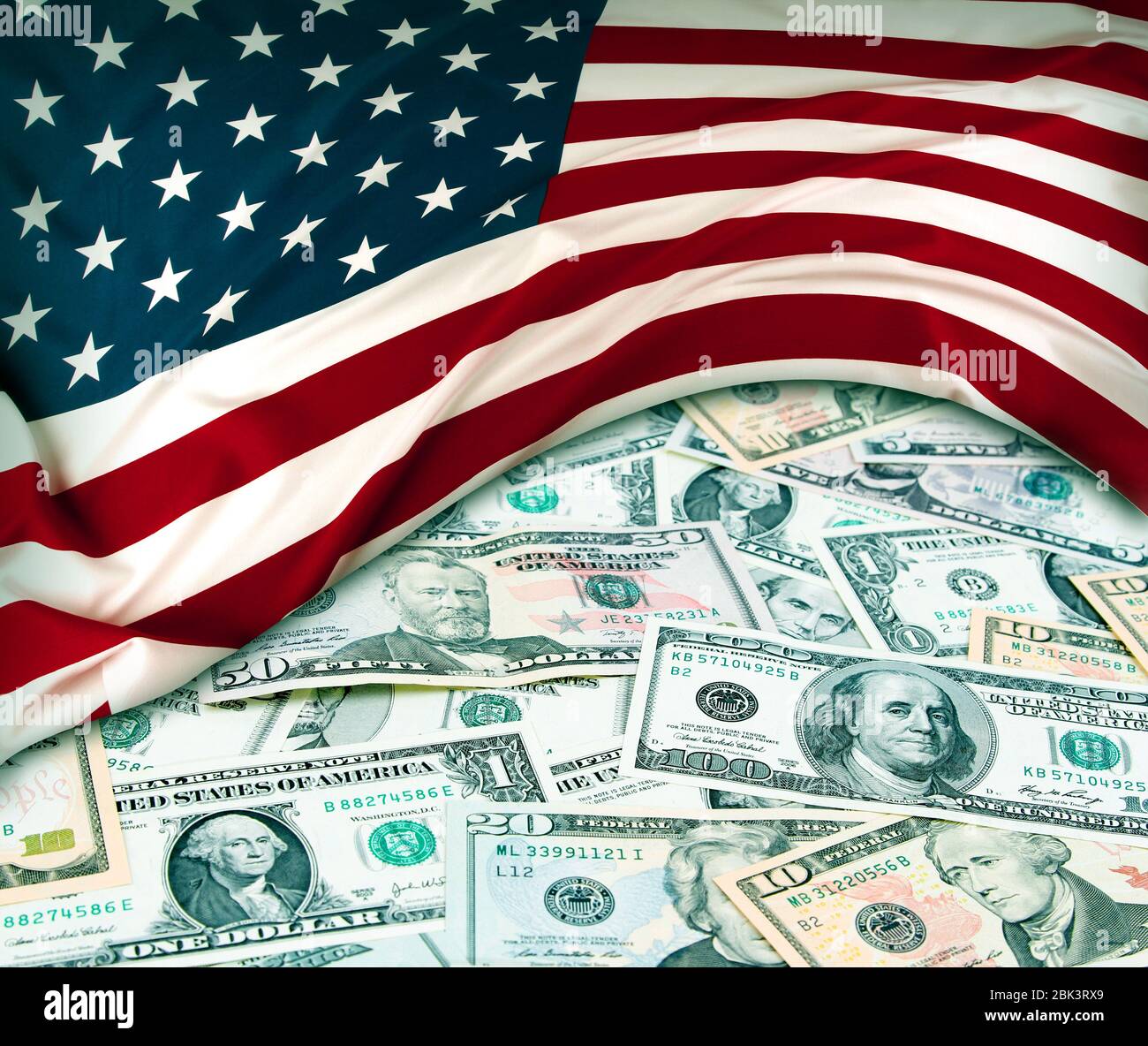 Bandiera americana e un assortimento di banconote americane Foto Stock