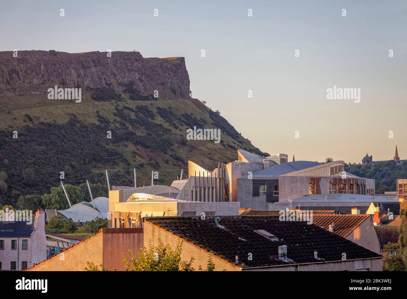 Salisbury Crags a Edimburgo, che si affaccia sui tetti del centro scientifico e dell'attrazione per i visitatori della Terra dinamica e del Parlamento scozzese (Holyrood) Foto Stock