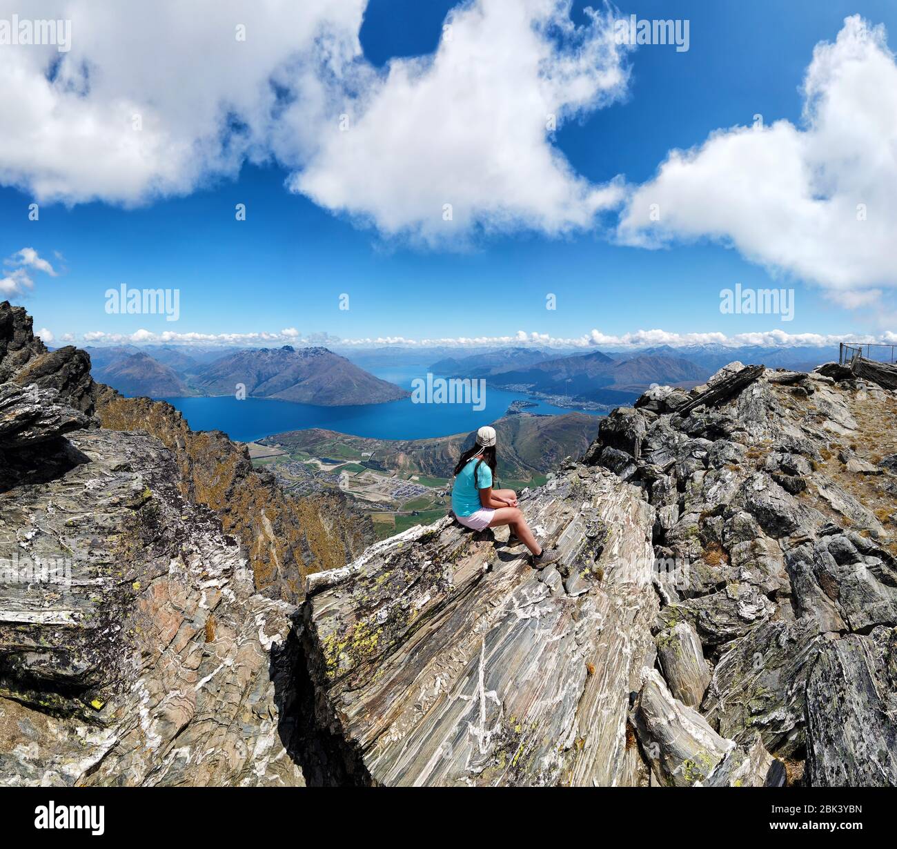 L'escursionista si trova sulle rocce della catena montuosa Remarkables, Queenstown, Otago, South Island, Nuova Zelanda, Oceania. Foto Stock