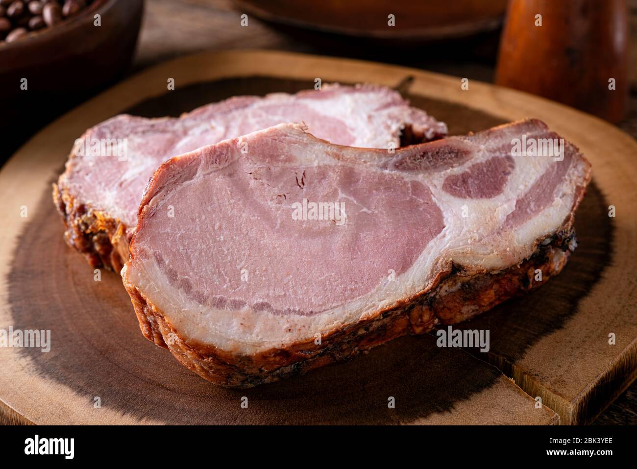 Deliziose costolette di maiale affumicate su un tagliere rustico in legno. Foto Stock