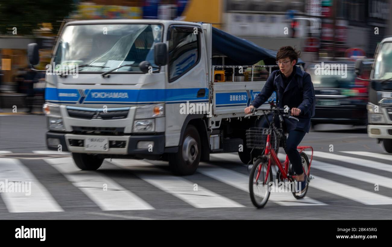 Ciclista che si insenatura Shibuya, Tokyo, Giappone Foto Stock