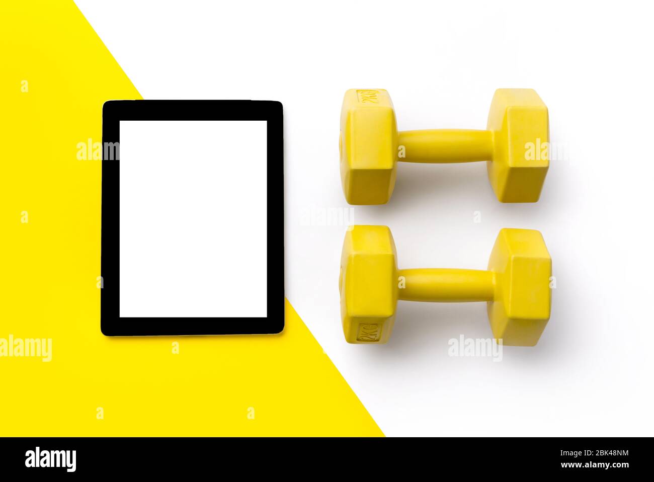 Piano piano superiore vista manubri e tablet su sfondo bianco e giallo doppio Foto Stock
