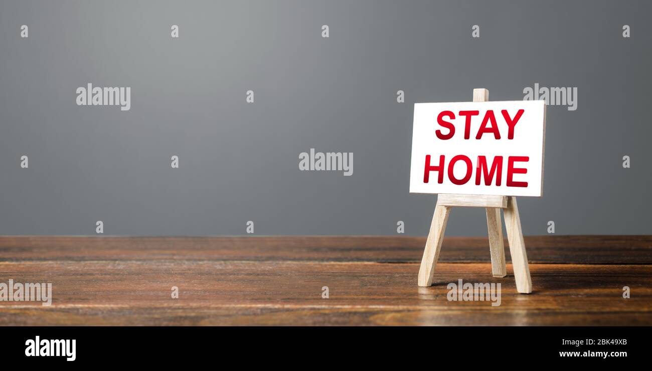 Cavalletto con una parola soggiorno a casa. Misure severe per fermare nuove infezioni di coronavirus COVID-19 crescita esponenziale. Restrizioni amministrative in contagio Foto Stock