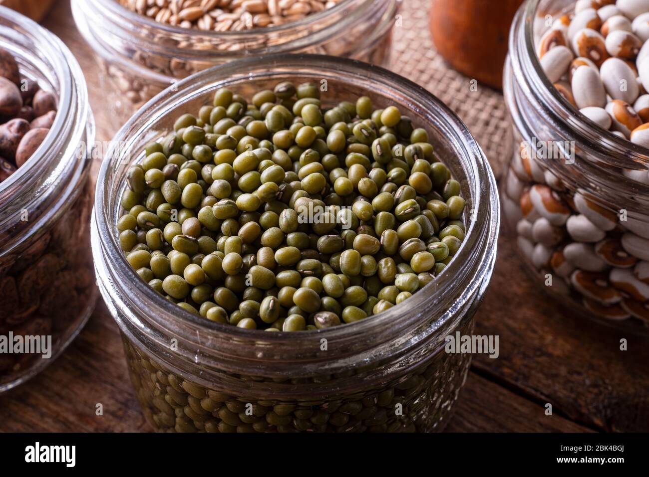 Fagioli di mung verdi in un contenitore di conservazione di vetro. Foto Stock