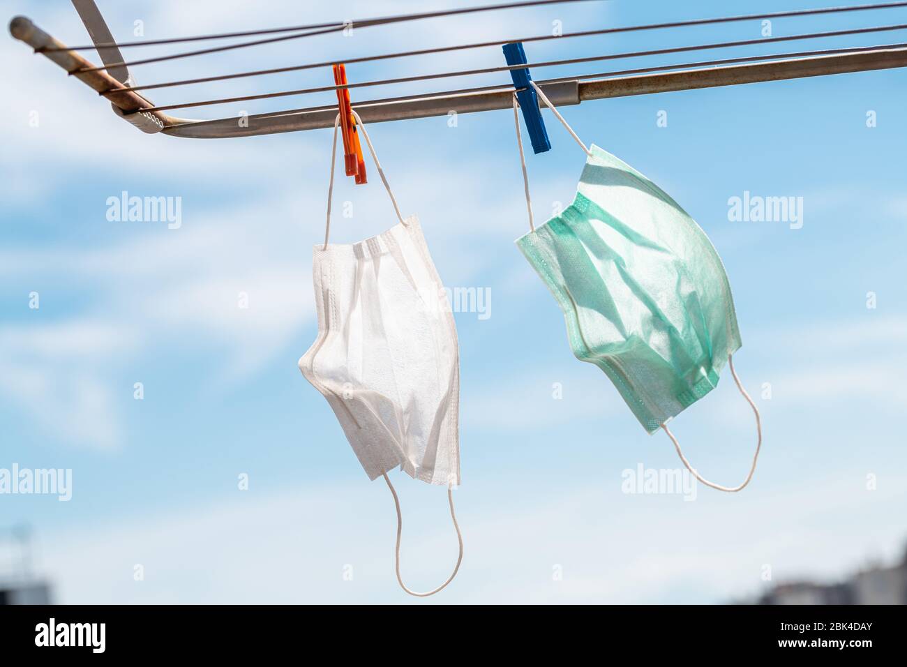 Maschera medica protettiva appesa alla linea di abbigliamento durante la quarantena pandemica del coronavirus Covid-19 Foto Stock