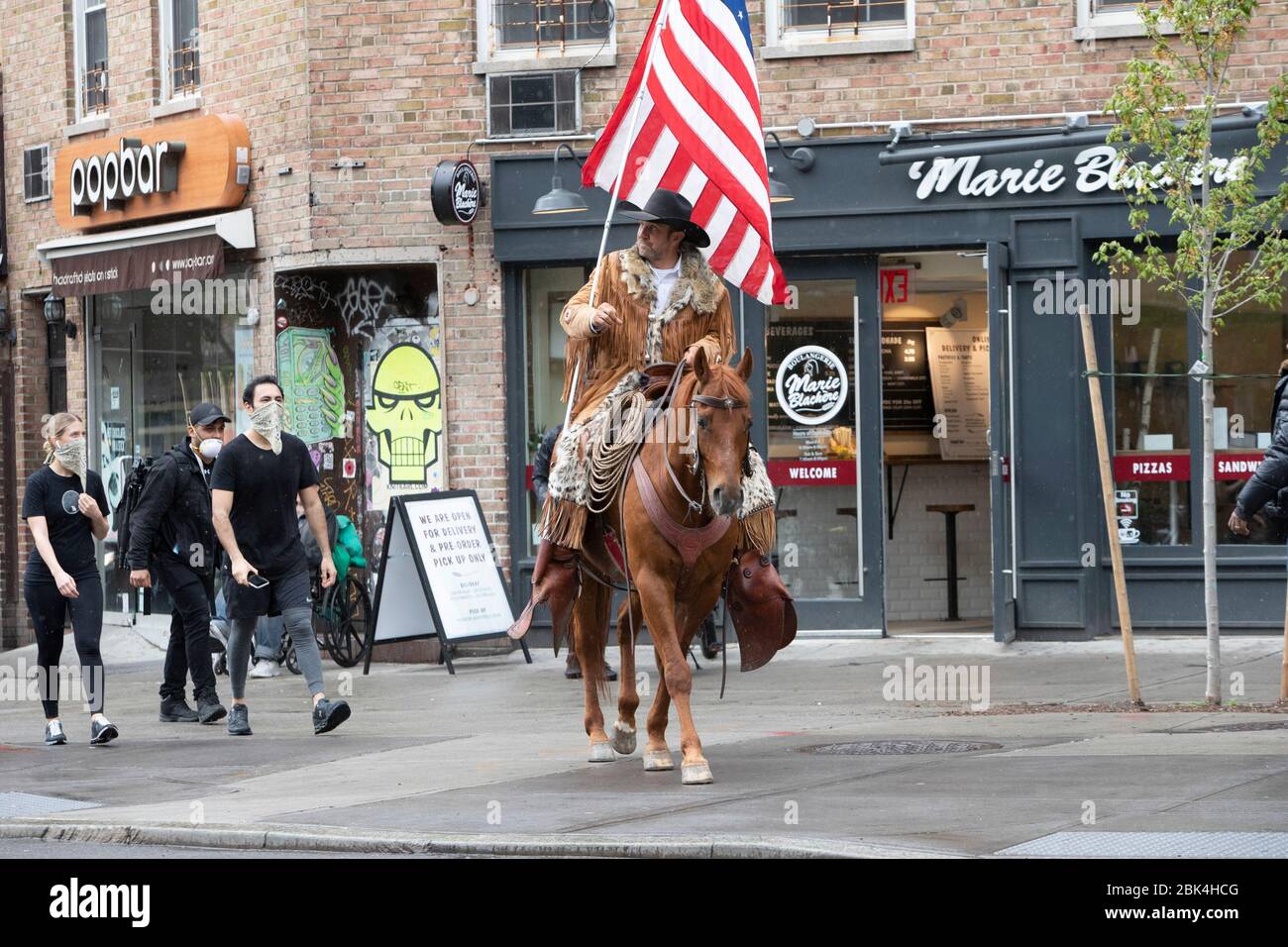 New York, New York, Stati Uniti. 1° maggio 2020. Couy Griffin di Tularosa, New Mexico, cavalca il suo cavallo sulla Sixth Avenue nella sezione Greenwich Village di New York, New York. Griffin ha iniziato il suo viaggio la Domenica di Pasqua a San Francisco, California per conto di Cowboys per Trump'' che è un'organizzazione che sostiene Trumps '' Make America Great Again'' politiche Credit: Brian Branch Price/ZUMA Wire/Alamy Live News Foto Stock