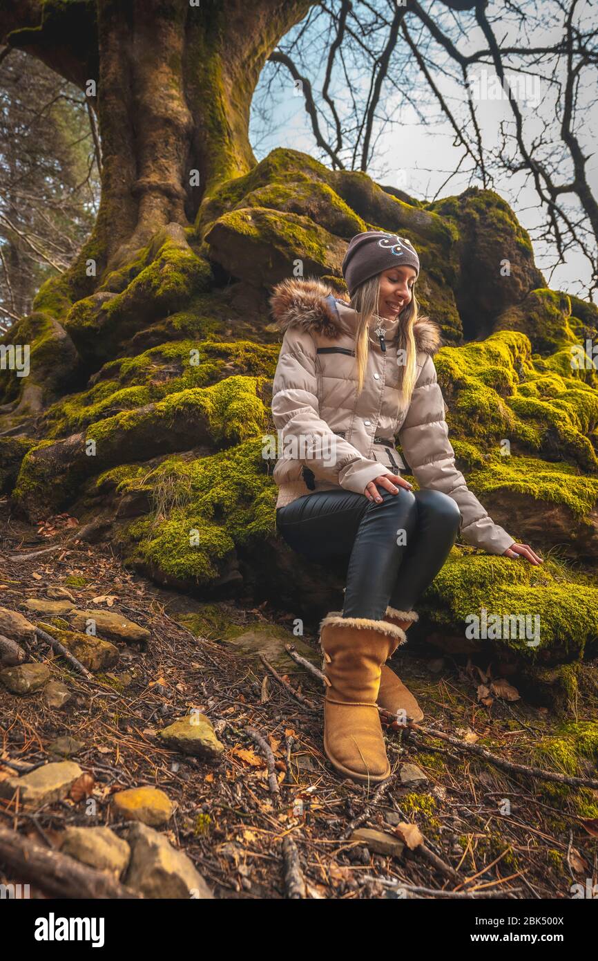 Una giovane bionda con capelli biondi godendosi seduto in un bella foresta Foto Stock