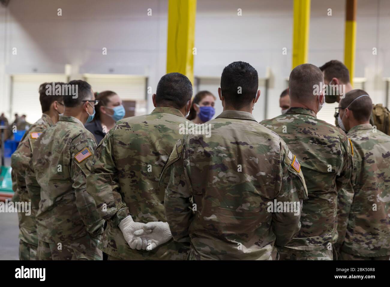 I leader e gli ufficiali del plotone si stringono con il personale della Food Lifeline Covid-19 Response Food Bank di Seattle il 1° maggio 2020. Food Lifeline, insieme a SSA Marine, Columbia Hospitality e Prologis, con l'assistenza della Washington Army e Air Force National Guard, ha creato una banca alimentare supplementare di 160,000 metri quadrati in risposta all'aumento della domanda di soccorso alimentare nella regione, in mezzo alla pandemia COVID-19. Foto Stock