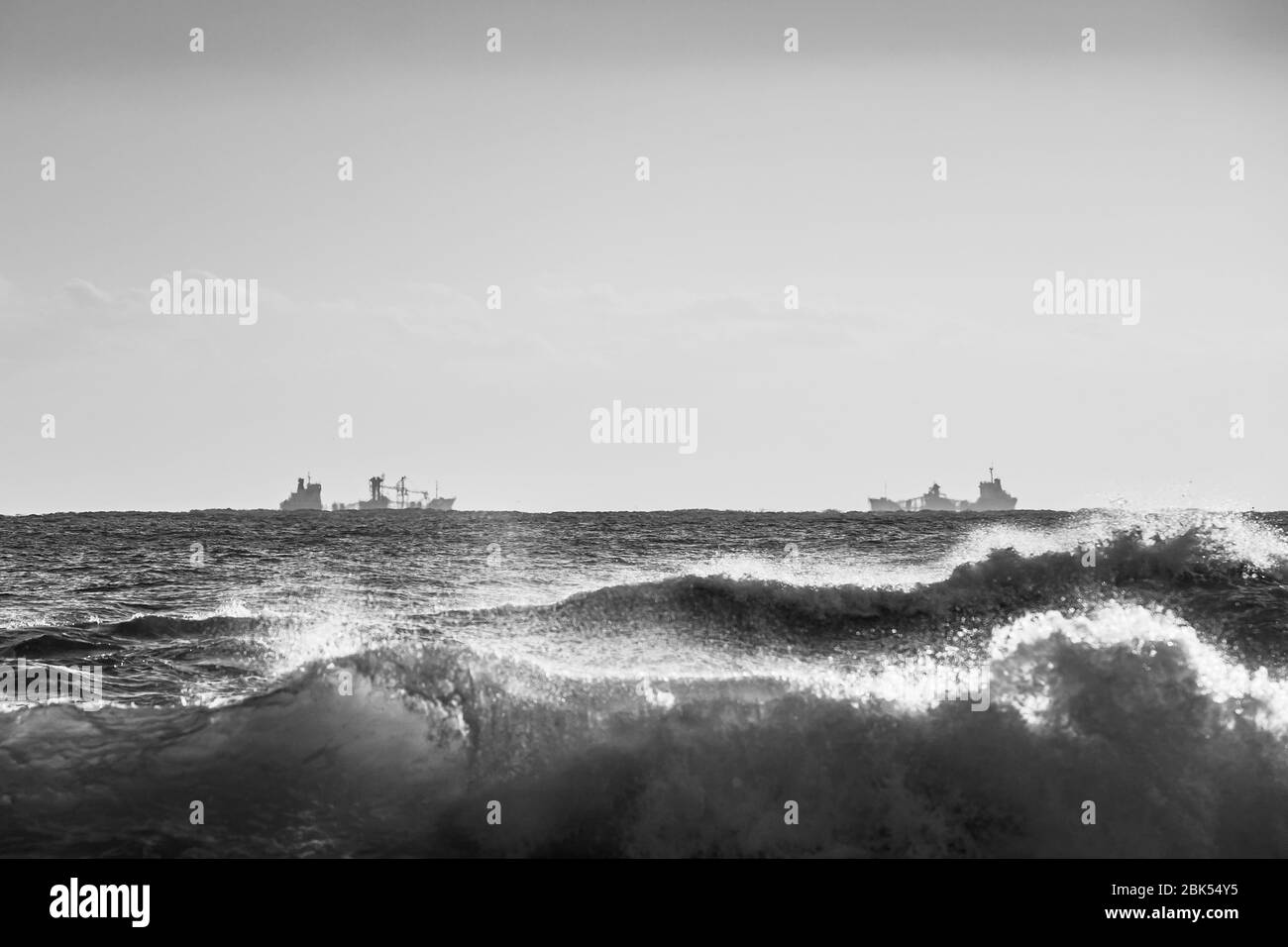 Bianco/nero, bellissimo paesaggio di onde che arrivano al mare con due barche da pesca, East Seaside, Uljin-gun, Corea Foto Stock