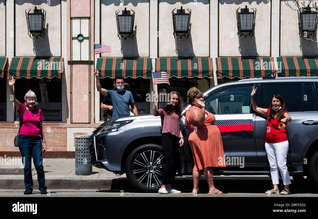 Persone che indossano la maschera e sventolano la bandiera americana Foto Stock