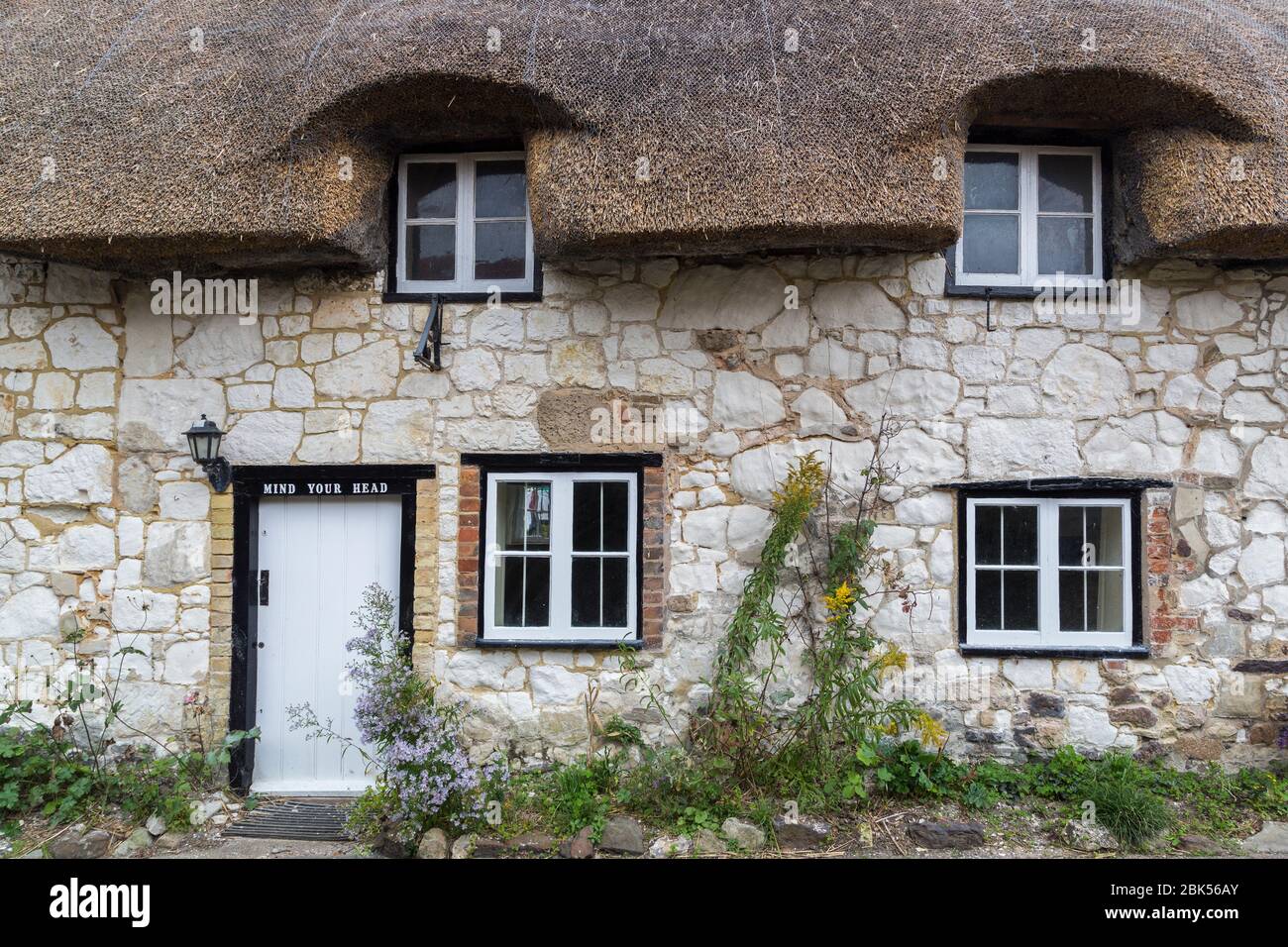 Porta in pietra cottage con mente il tuo cartello testa, Brighstone, Isle of Wight, Inghilterra, Regno Unito Foto Stock