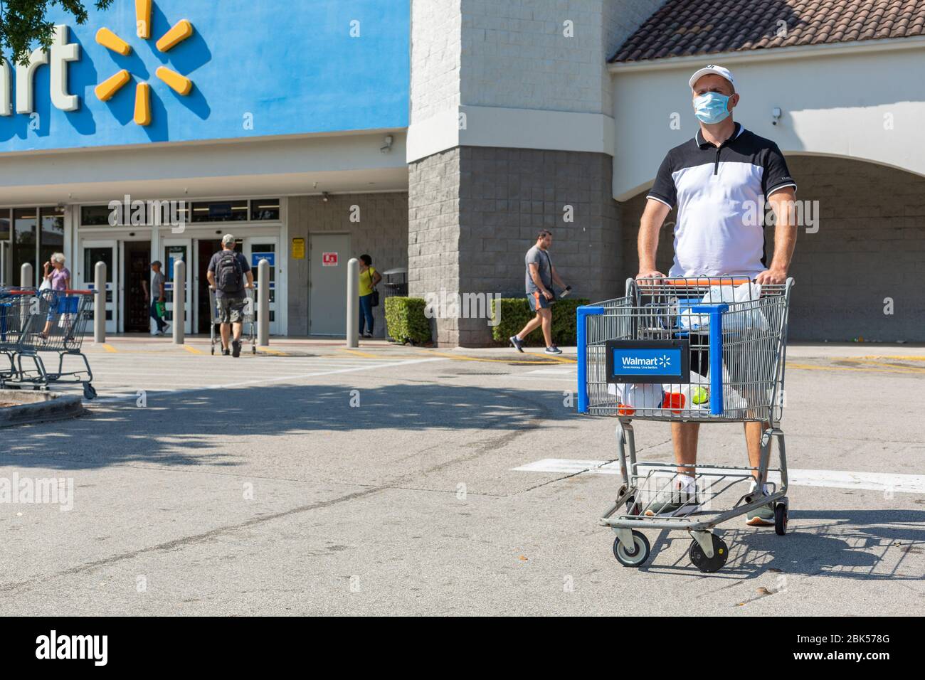 Uomo che indossa la maschera medica sul Walmart negozio spazio parcheggio. Tempo di quarantena per Coronavirus. Foto Stock