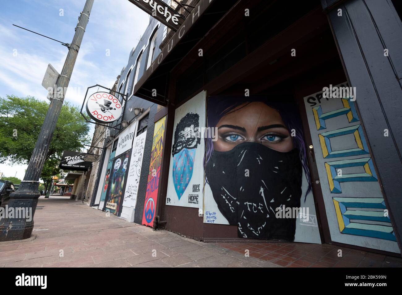 I colorati murales decorano le facciate dei bar e dei ristoranti a bordo di un bar, nel quartiere dei divertimenti di Austin, in genere vivace Sixth Street. Ad Austin, Texas, sei settimane dopo una chiusura per affari a causa della pandemia del coronavirus. Foto Stock