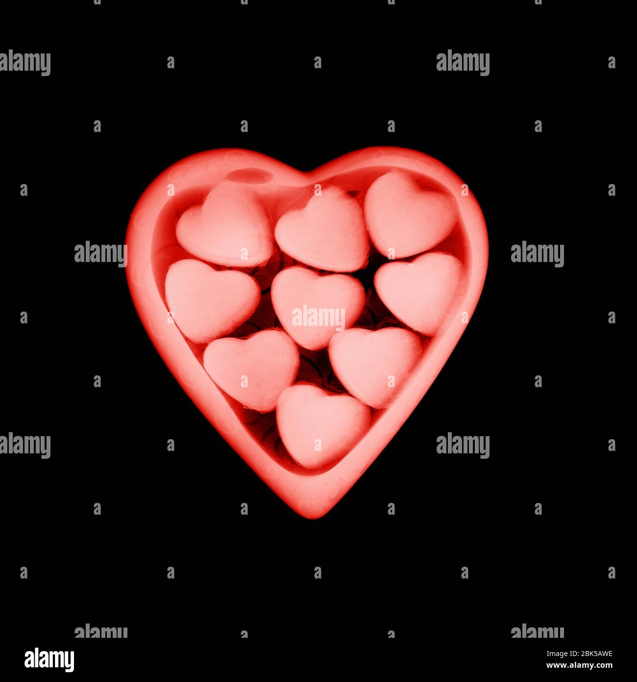 Cioccolatini a forma di cuore in una scatola, radiografia colorata. Foto Stock