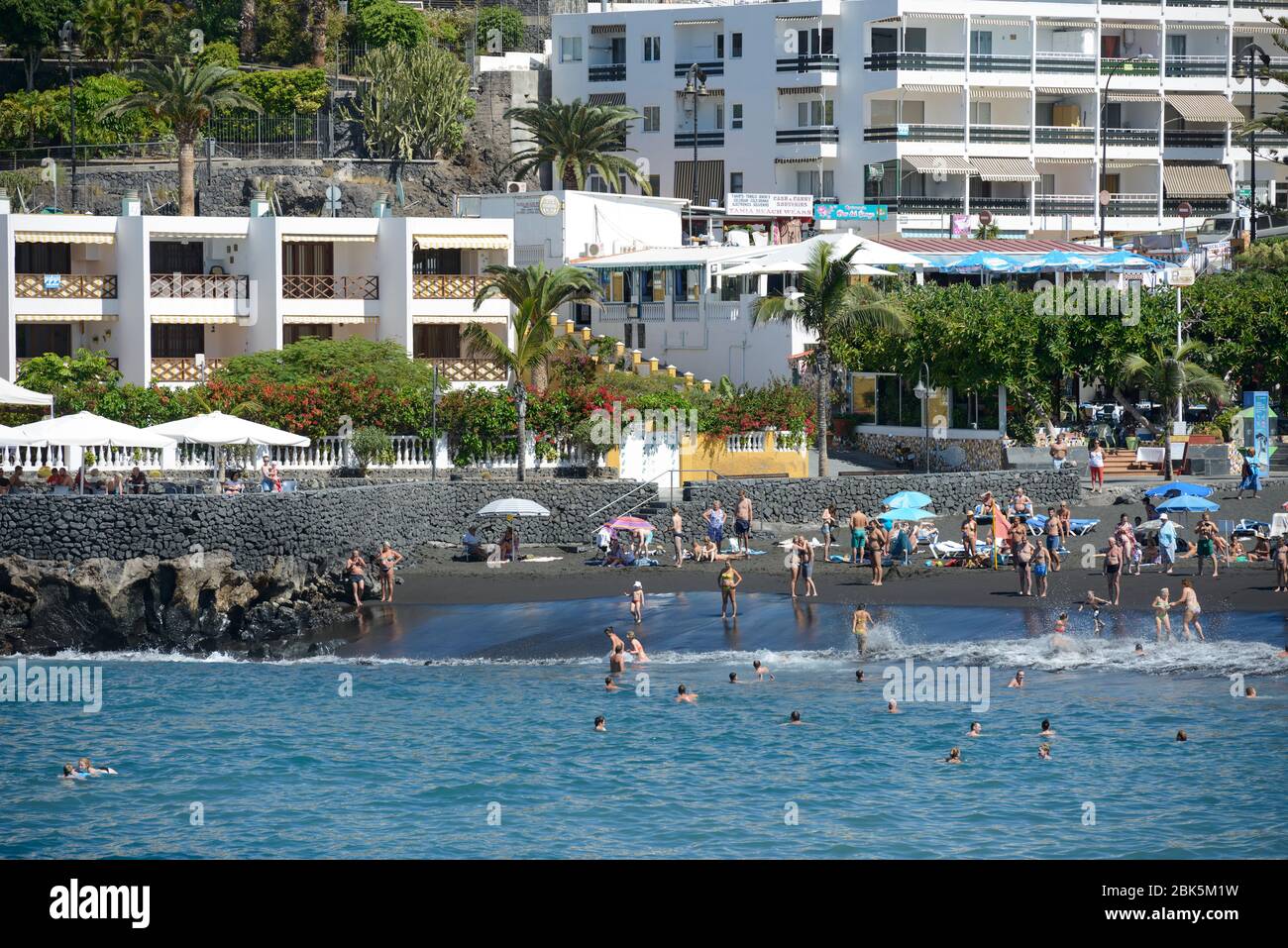 Vista panoramica verso la famosa spiaggia di Arana con sabbia vulcanogena nera a Puerto de Santiago dall'acqua, Tenerife, Isole Canarie, Spagna. Foto Stock