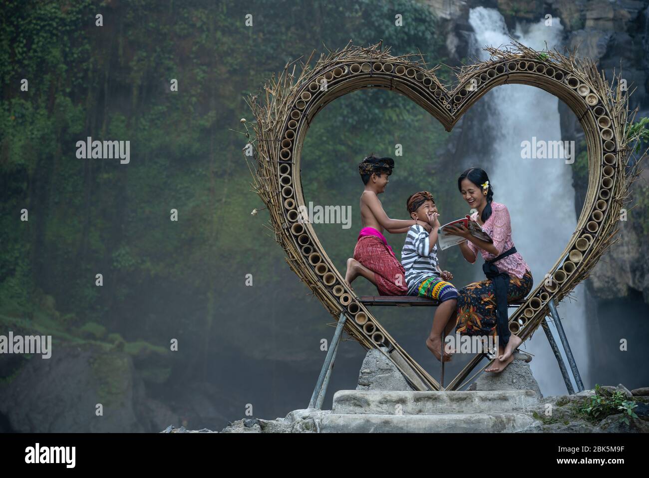 Cascata di Blangsinga, Blahbatuh, Gianyar, Bali, Indonesia - 29 giugno 2019 : sorella maggiore con i suoi fratelli più giovani alla cascata di Blangsinga Foto Stock