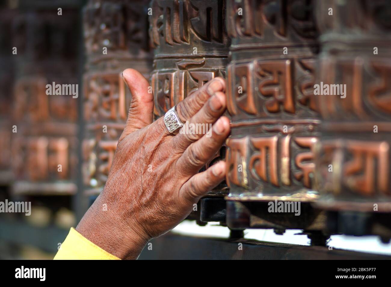 Ruota della preghiera con Mantra 'Om mani Padme Hum', un antico mantra buddista. In inglese, questo canto ritmico si traduce letteralmente in "lode all'ebreo Foto Stock