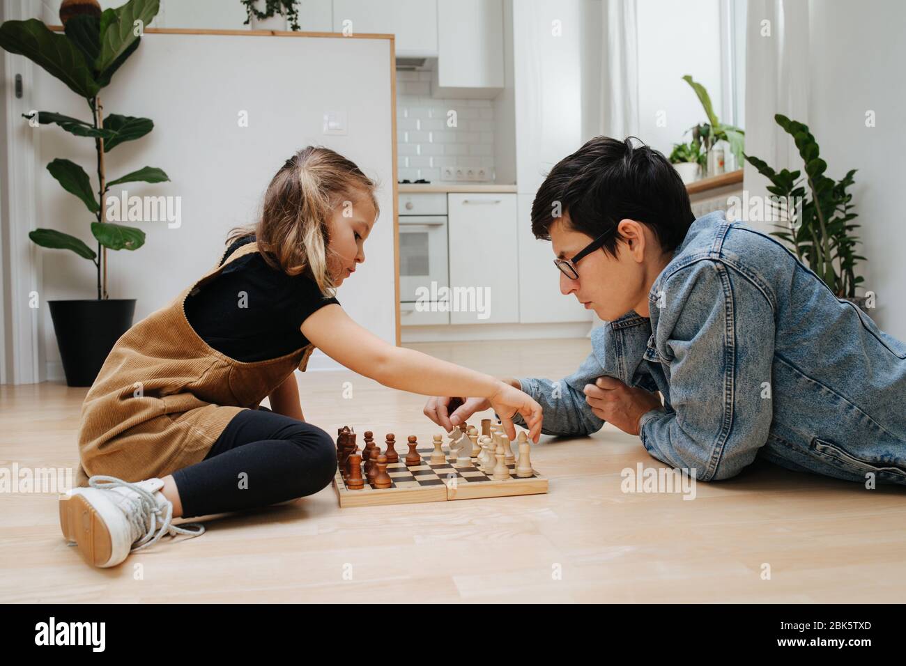 Papà e dau imparano a scacchi su un piano cucina a casa Foto Stock