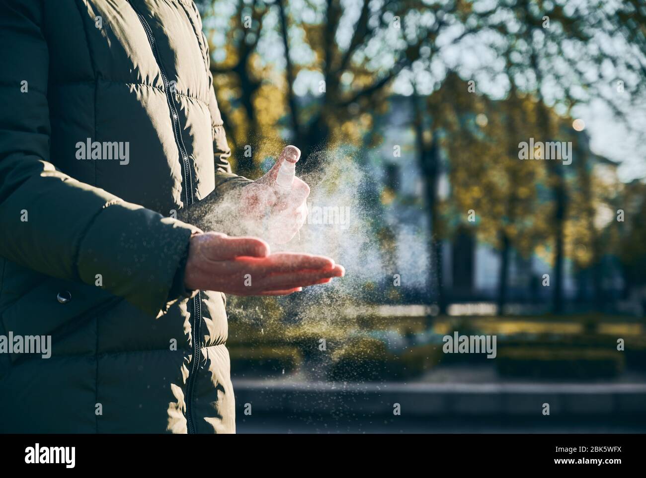 Un'istantanea ravvicinata delle mani della donna che le strofinano le mani con spray a base di alcol, il giorno di sole, come misura igienica preventiva contro l'infezione da coronavirus. Foto Stock