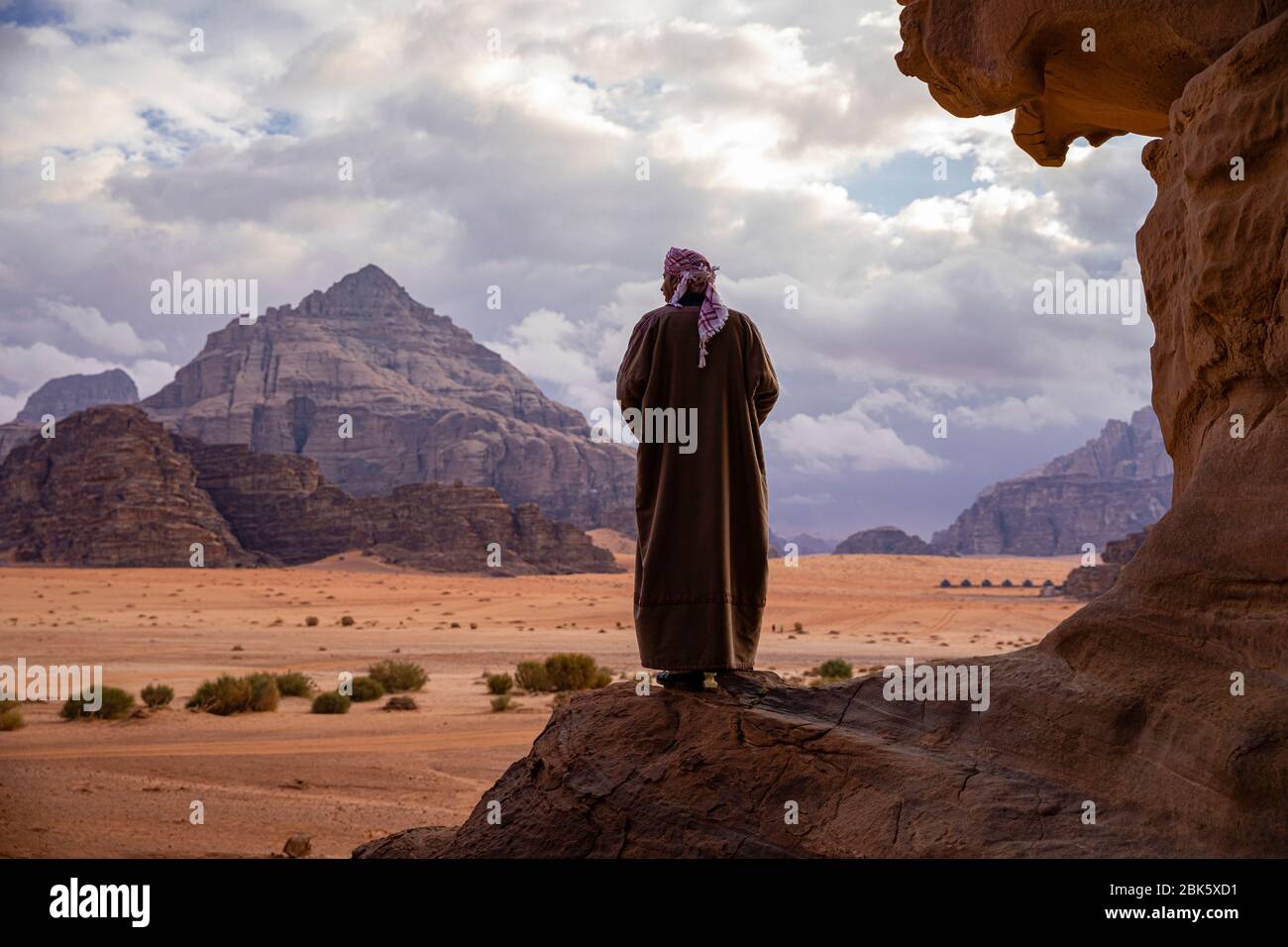 Beduino che guarda il paesaggio desertico di Wadi Rum, Giordania Foto Stock