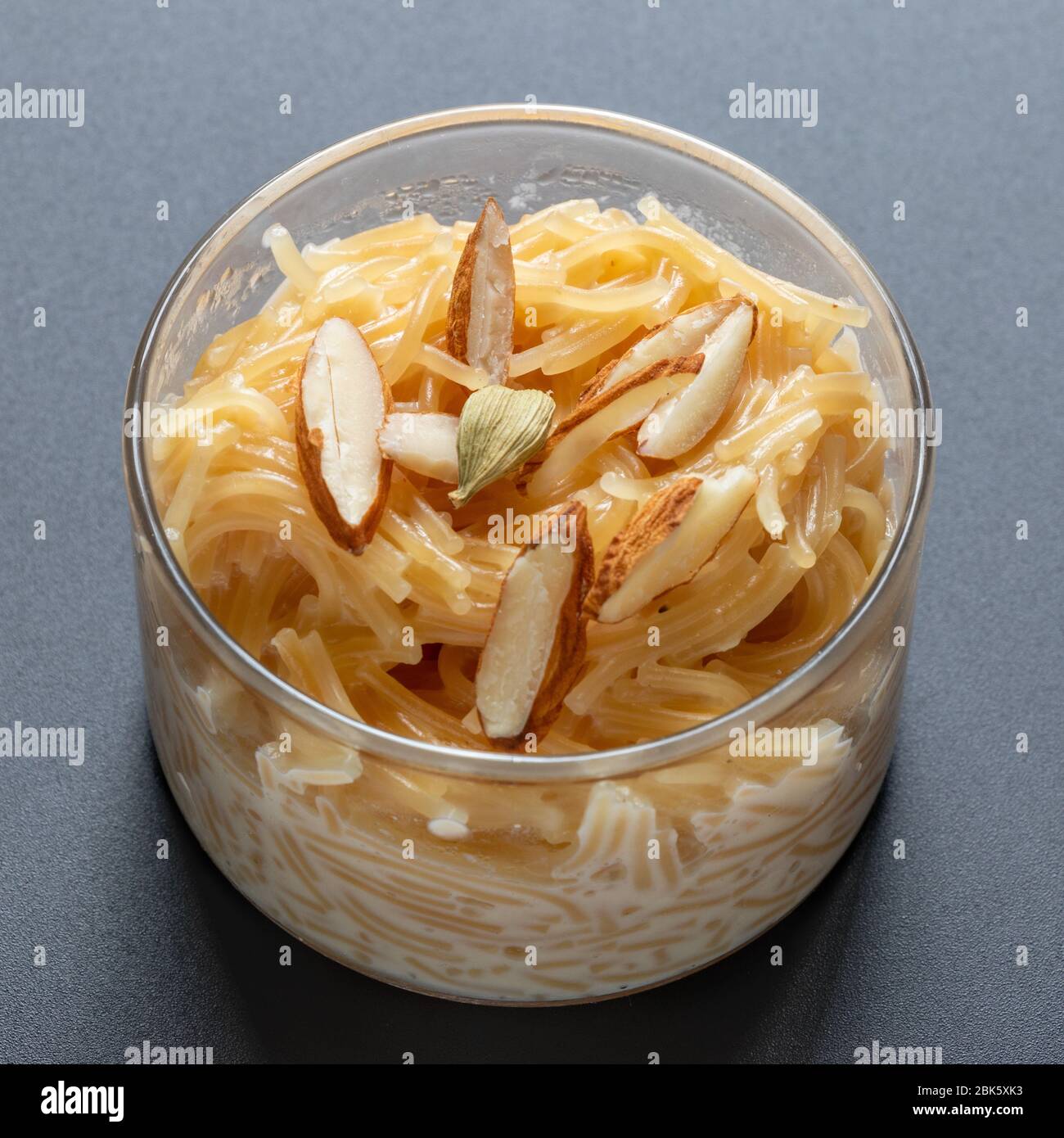 Dessert Vermicelli, popolare dolce piatto conoscere un kheer fatto con latte e guarnire con frutta secca isolato su sfondo grigio scuro, servito in ciotola di vetro. Foto Stock