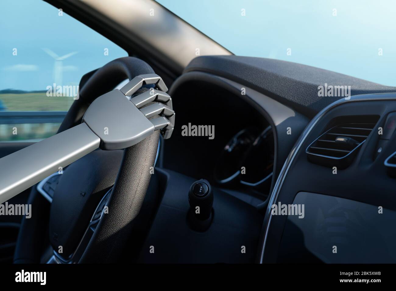 Braccio del robot su un volante. L'intelligenza artificiale guida un'auto. Concetto di veicolo autonomo. Foto Stock
