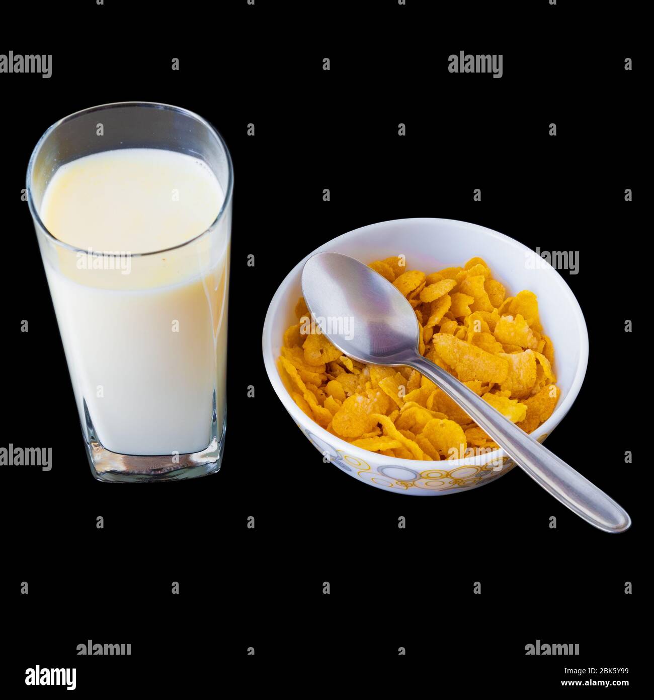 Fiocchi di mais con latte in ciotola isolato su sfondo grigio nero, una deliziosa dieta e sano cereali da colazione. Foto Stock