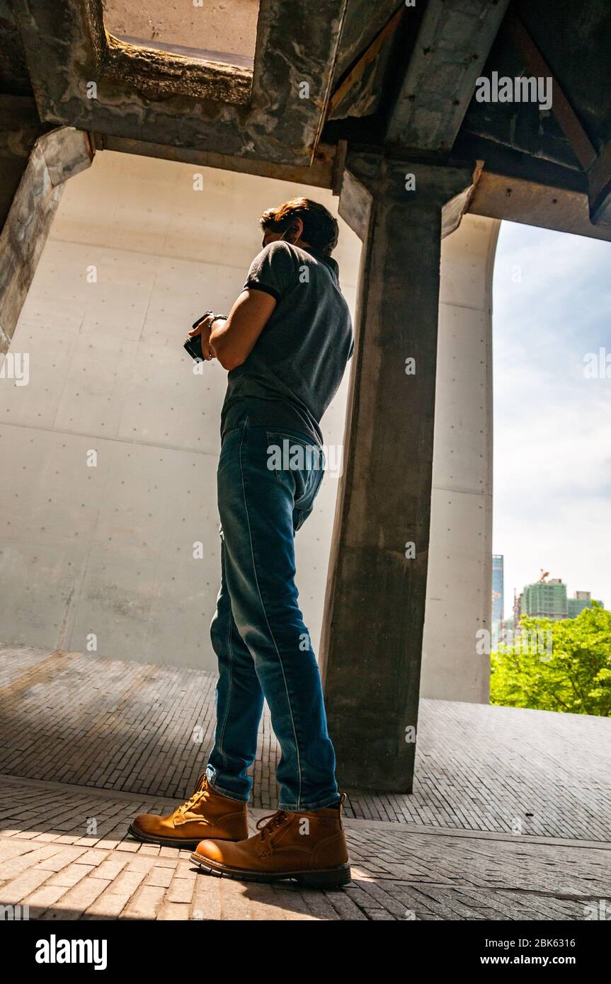 Un fotografo straniero di sesso maschile spara l'apertura di una shute per caricare carri di carbone con carbone scaricato dalle chiatte sul fiume Huangpu conservato presso il Foto Stock