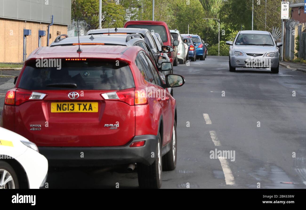 Le persone si accodano nelle loro automobili al di fuori di un impianto di riciclaggio dei rifiuti domestici a Manchester, che si è riaperto oggi dopo la chiusura a marzo a causa dell'epidemia di coronavirus. Foto Stock