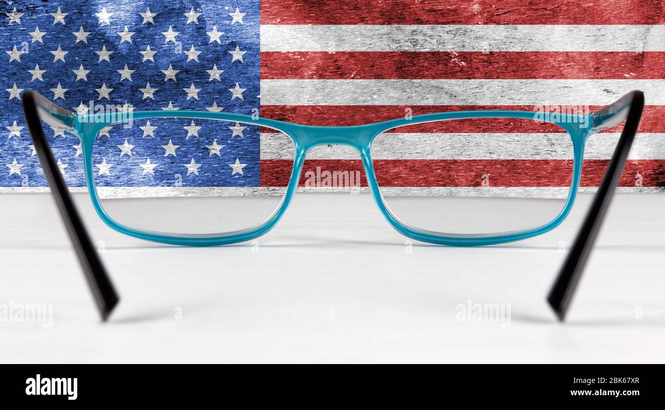Bandiera creativa degli Stati Uniti visto attraverso un paio di occhiali che giacciono su un tavolo bianco Foto Stock
