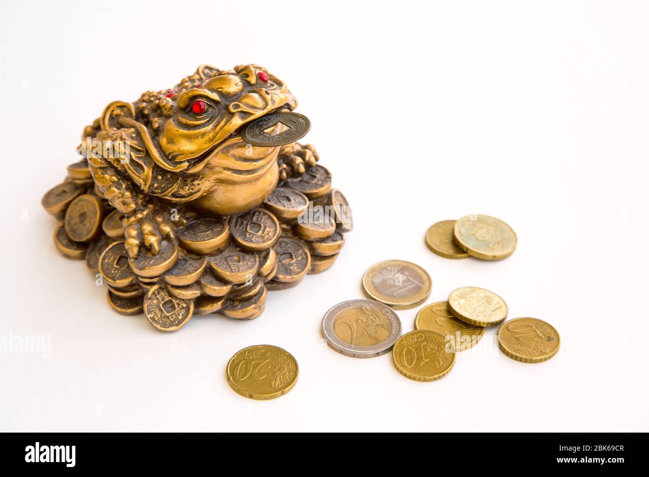 Denaro rana feng shui simbolo di prosperità e monete in euro isolato su sfondo bianco Foto Stock