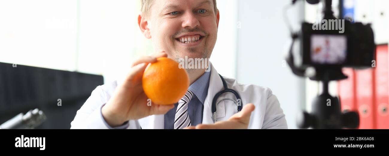 Il medico nutrizionista parla di benefici arancione Foto Stock