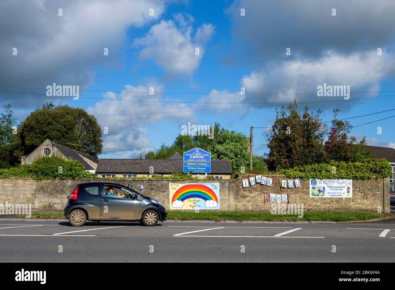 Chippenham, Wiltshire UK, 2 maggio 2020. Un autista che si allontana dall'ospedale di Chippenham è illustrato mentre passa davanti a un cartello "Thank You NHS" e "Thank You All Key Workers" appesi su un muro della scuola di fronte all'ospedale di Chippenham. Credit: Lynchpics/Alamy Live News Foto Stock