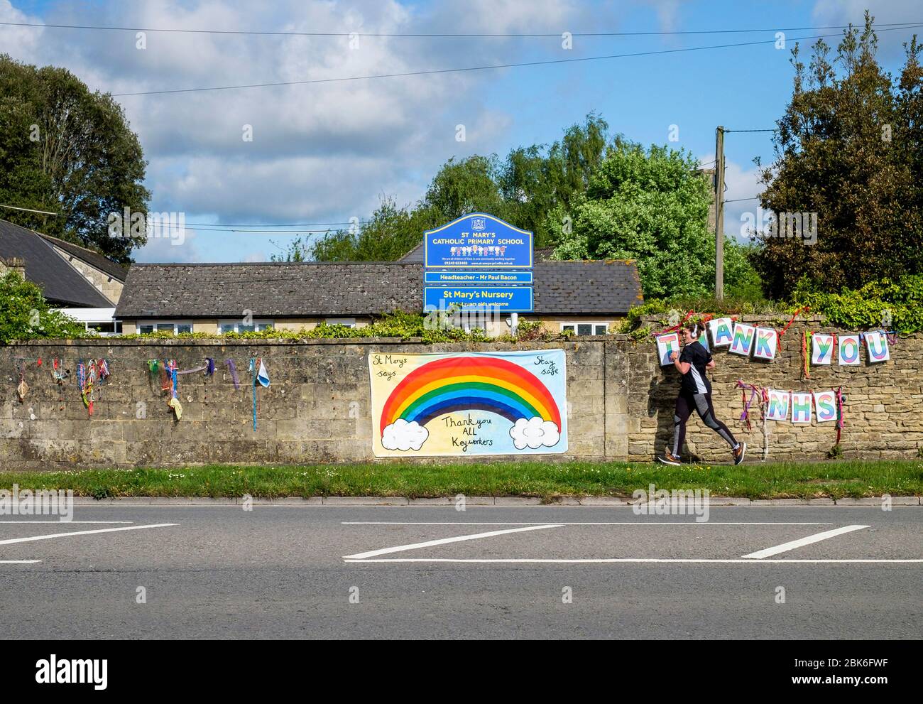 Chippenham, Wiltshire UK, 2 maggio 2020. Una persona che corre fuori è illustrata come loro corrono oltre 'Thank you NHS' e 'grazie tutti i principali lavoratori 'segni che sono stati appesi su un muro di scuola primaria di fronte al Chippenham Hospital. Credit: Lynchpics/Alamy Live News Foto Stock