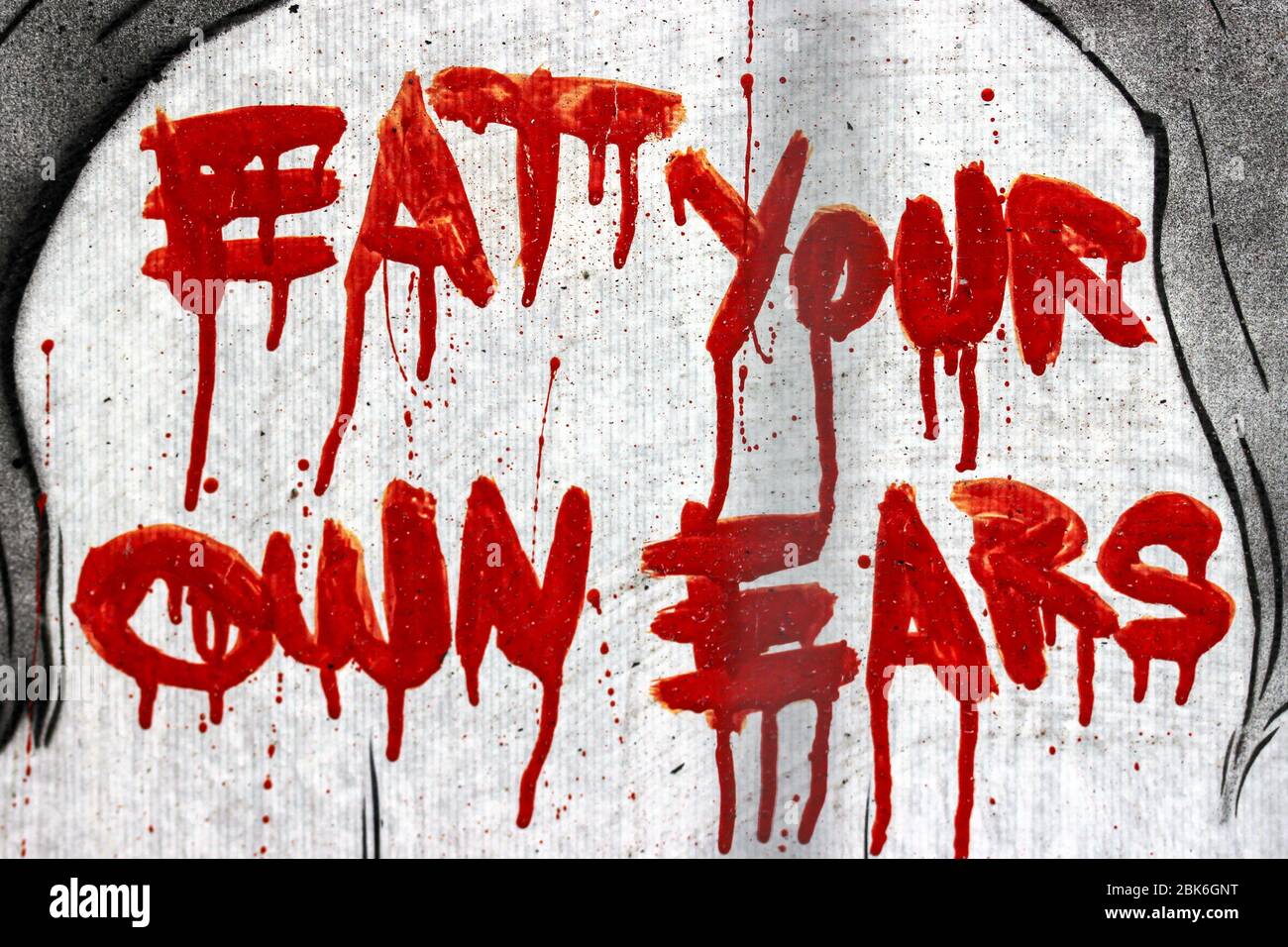 Mangia le tue orecchie - scritto con vernice rossa sul muro ad Amsterdam, Olanda Foto Stock