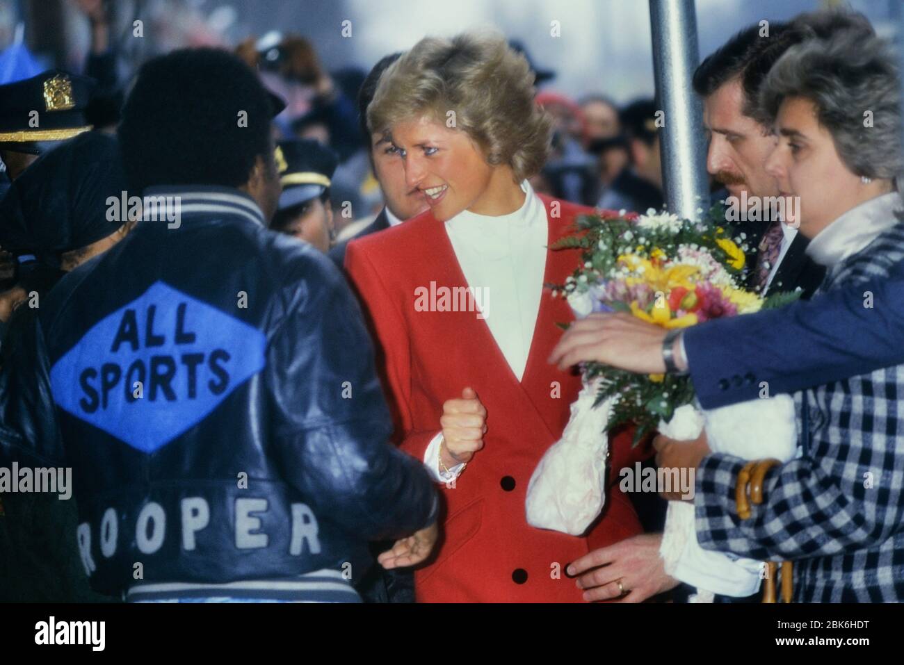 Diana, Principessa del Galles in una giacca rossa circondata da ben wishers visite Harlem pediatrica di unità di AIDS in Harlem. La città di New York, Stati Uniti d'America. 1989 Foto Stock