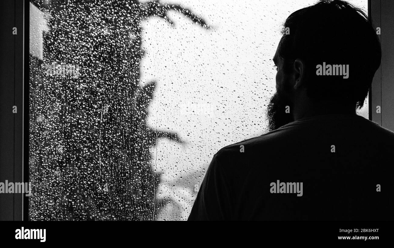 L'uomo guarda la pioggia attraverso una finestra immagini e fotografie  stock ad alta risoluzione - Alamy