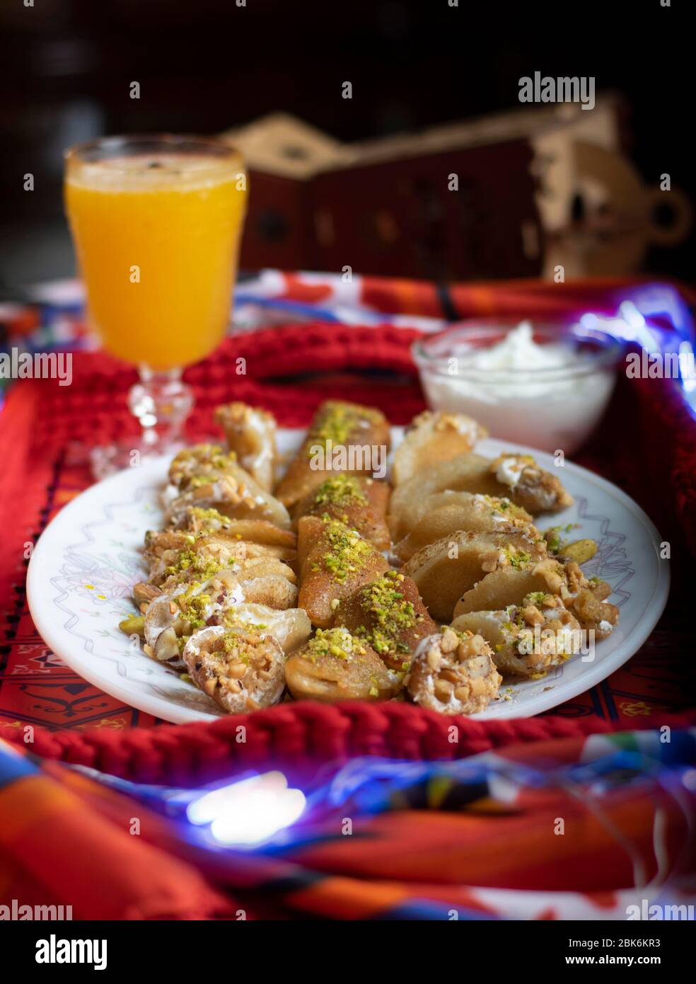 Dessert orientale chiamato Atayef con noci e bevanda orientale chiamato Amar el-din che sono fatti specialmente nel mese santo del Ramadan Foto Stock
