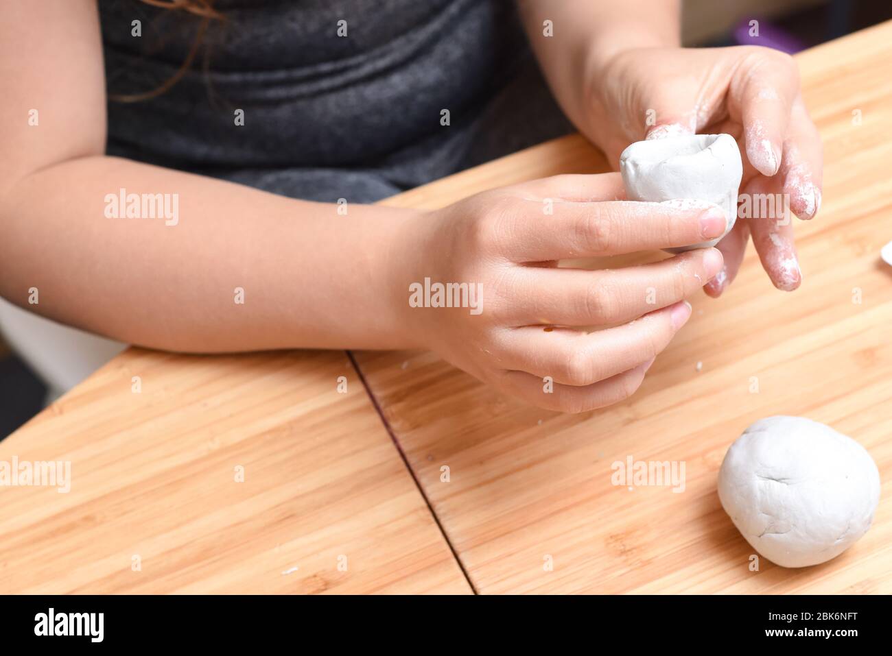 Ragazza che fa modelli di ceramica con argilla bianca a casa Foto Stock