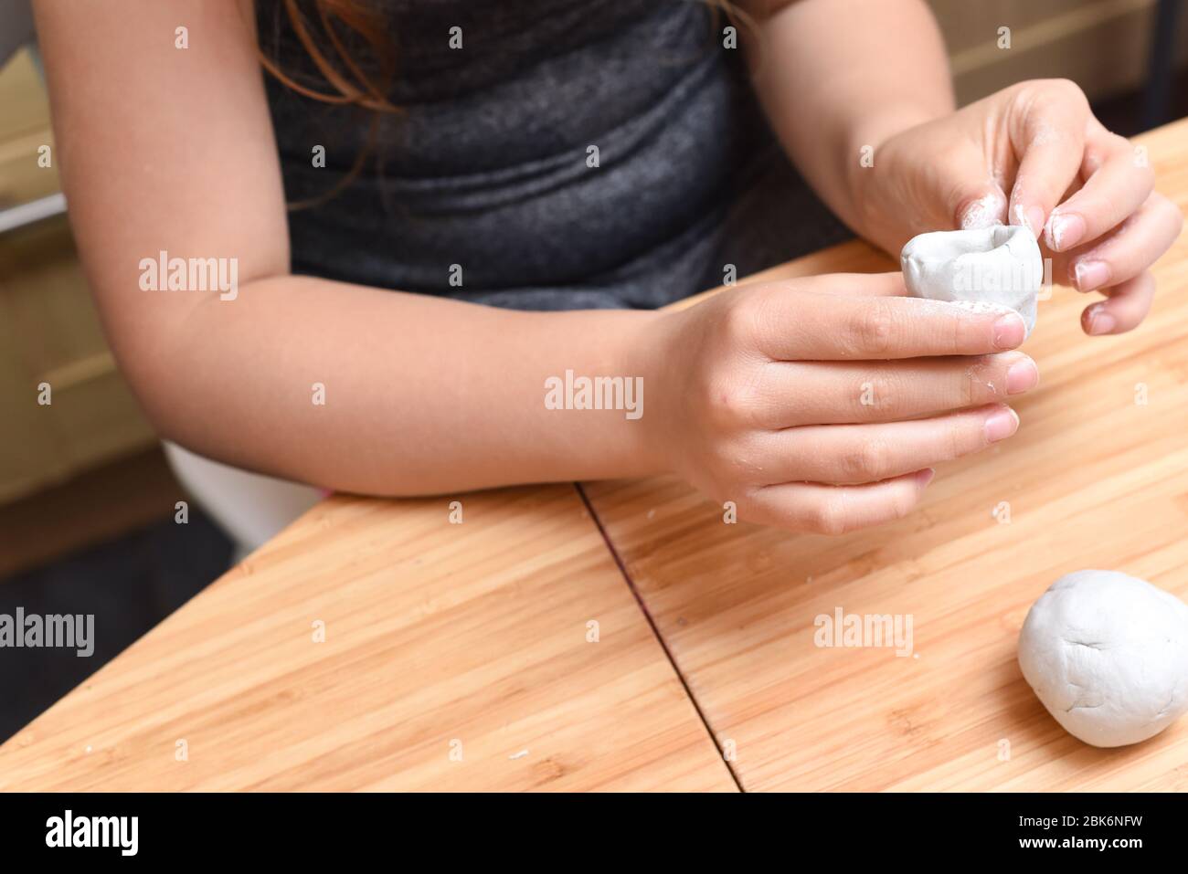 Ragazza che fa modelli di ceramica con argilla bianca a casa Foto Stock