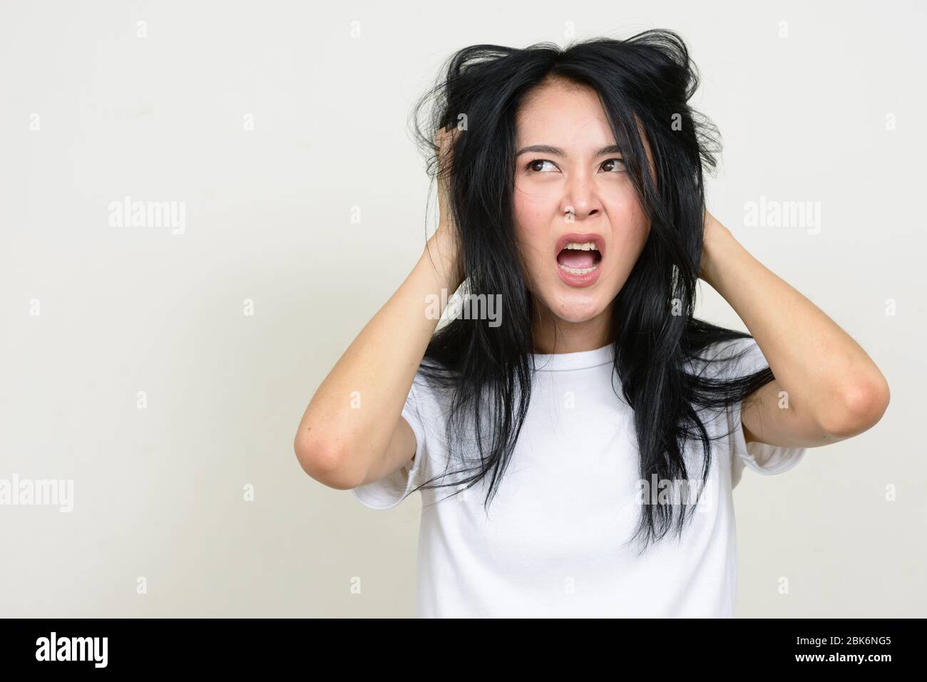 Ritratto di donna asiatica giovane stressata strappando i capelli fuori Foto Stock