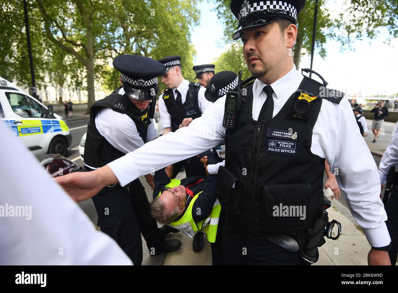 Un uomo viene portato via da poliziotti durante una protesta contro il blocco Covid-19 fuori dal New Scotland Yard a Londra. Foto Stock